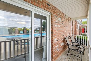 a porch with a pool and chairs and a sliding glass door